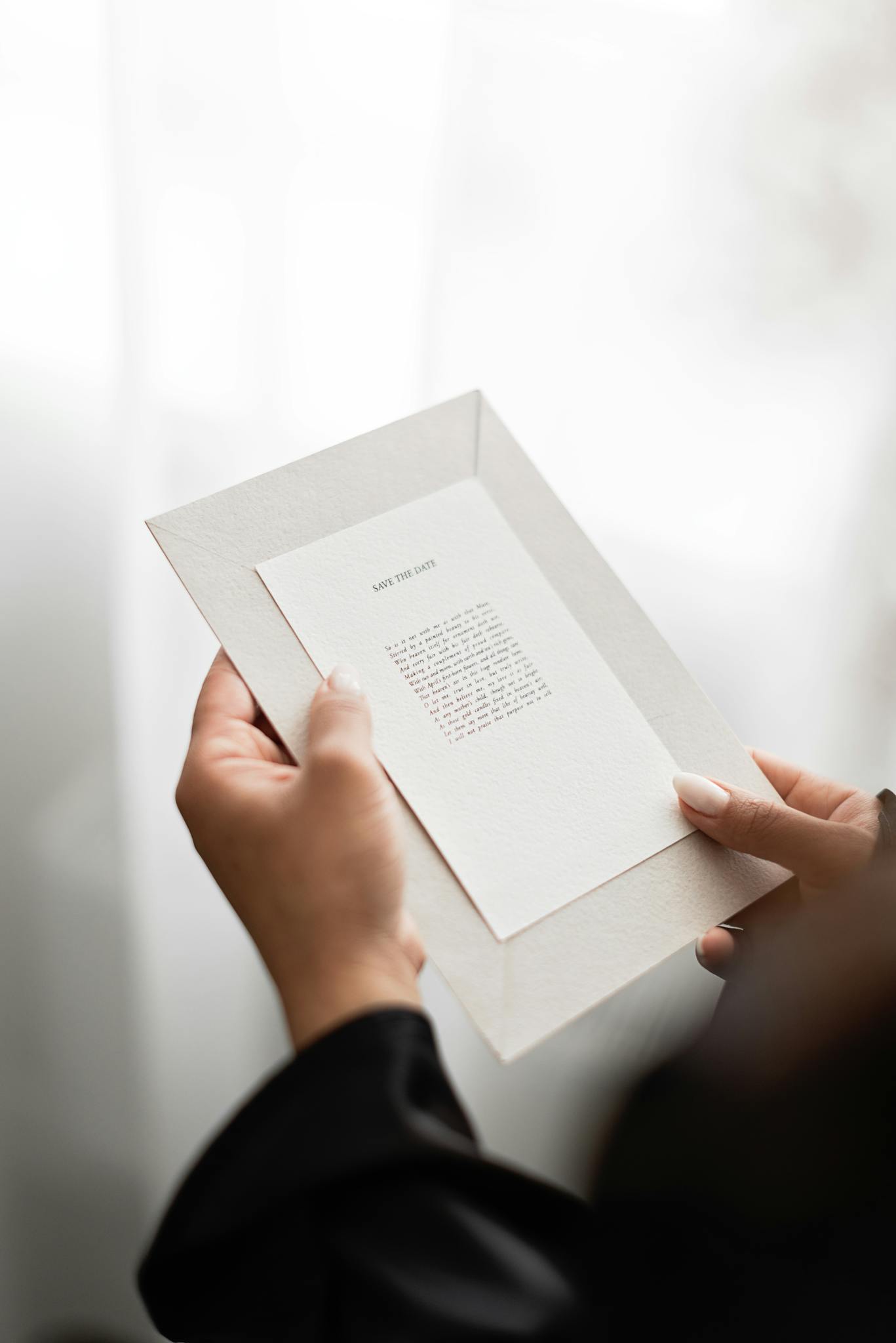Close-up of hands holding a wedding invitation, perfect for elegant events.
